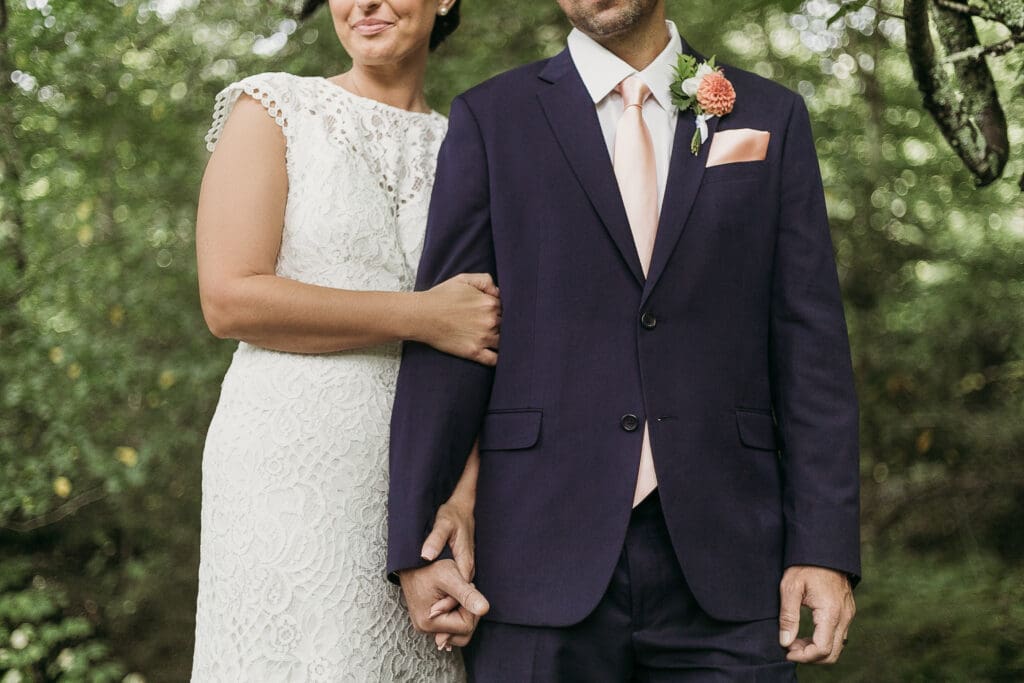 Bride and Groom having a moment in the woods surrounded by greenery having an intimate moment at their elopement.