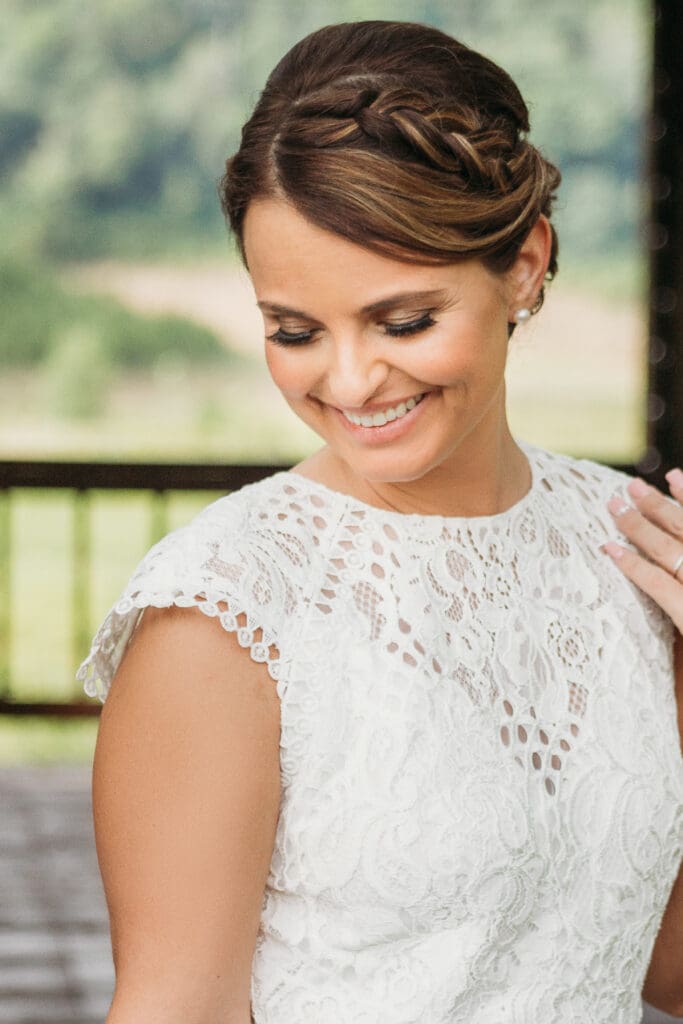 Bride at elopement standing under gazebo smiling big.
