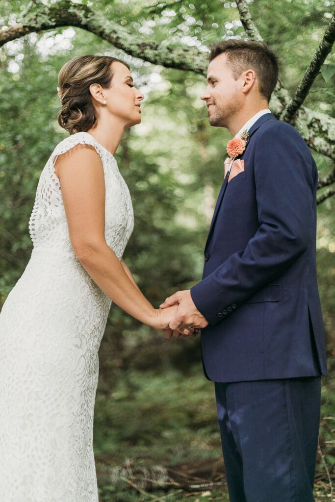 Bride and Groom having a moment in the woods surrounded by greenery having an intimate moment at their elopement.