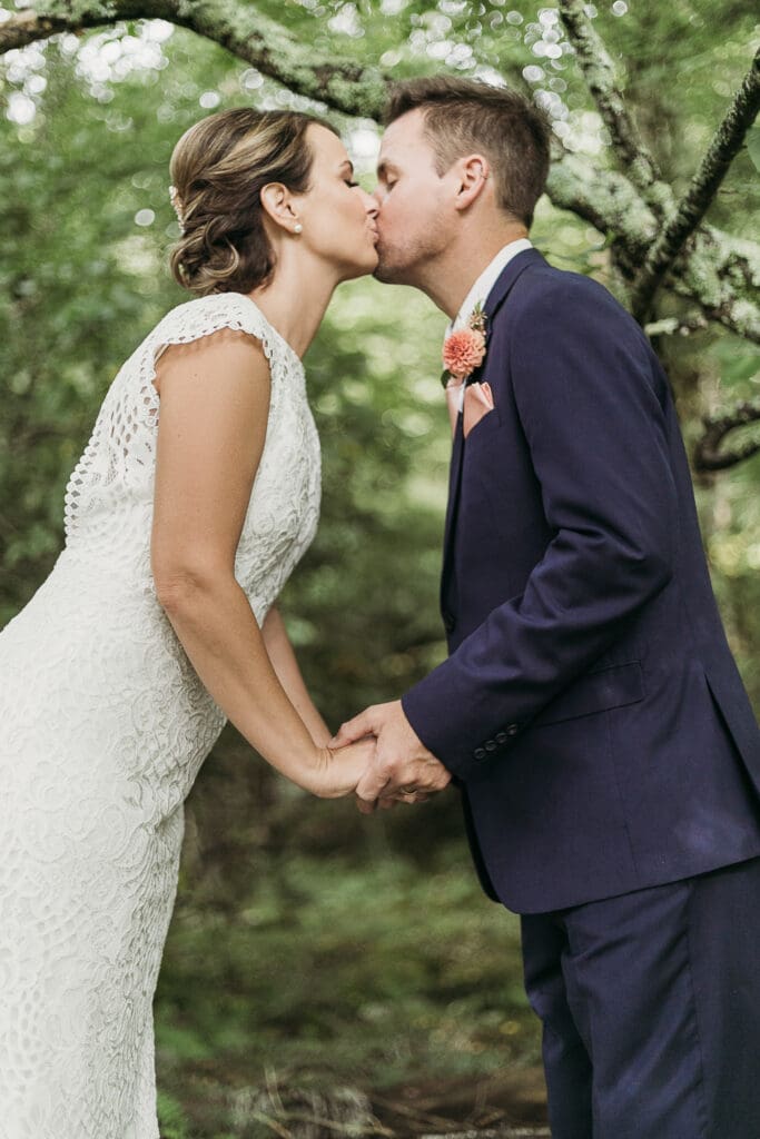 Bride and Groom having a moment in the woods surrounded by greenery having an intimate moment at their elopement.