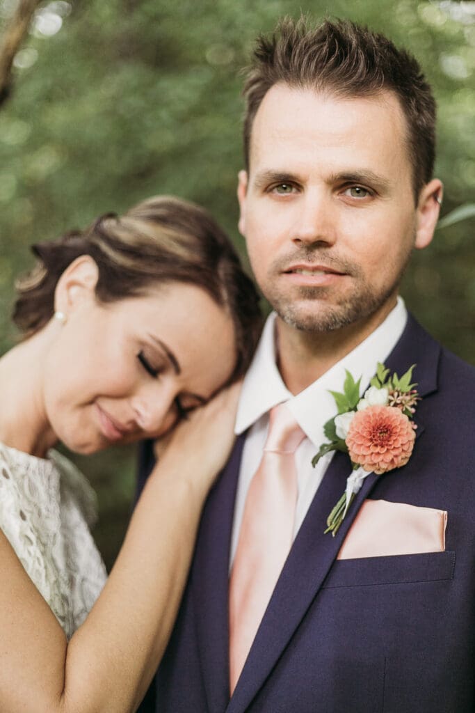 Bride and Groom having a moment in the woods surrounded by greenery having an intimate moment at their elopement.