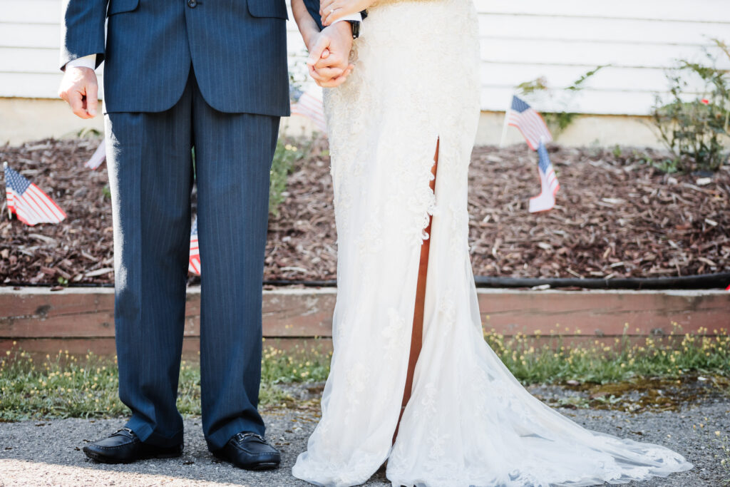 Couple eloping at a small chapel in the blue ridge mountains standing outside the white chapel with lush green landscape.