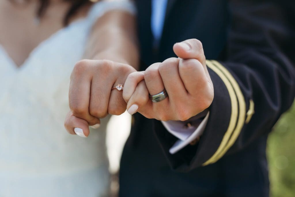 Couple on wedding day at thier elopement doing a pinky promise and showing off thier new wedding rings.
