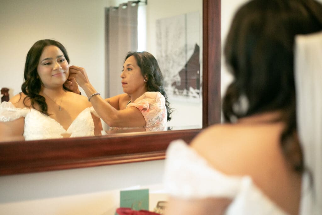 Mom helping bride getting ready for her wedding day.