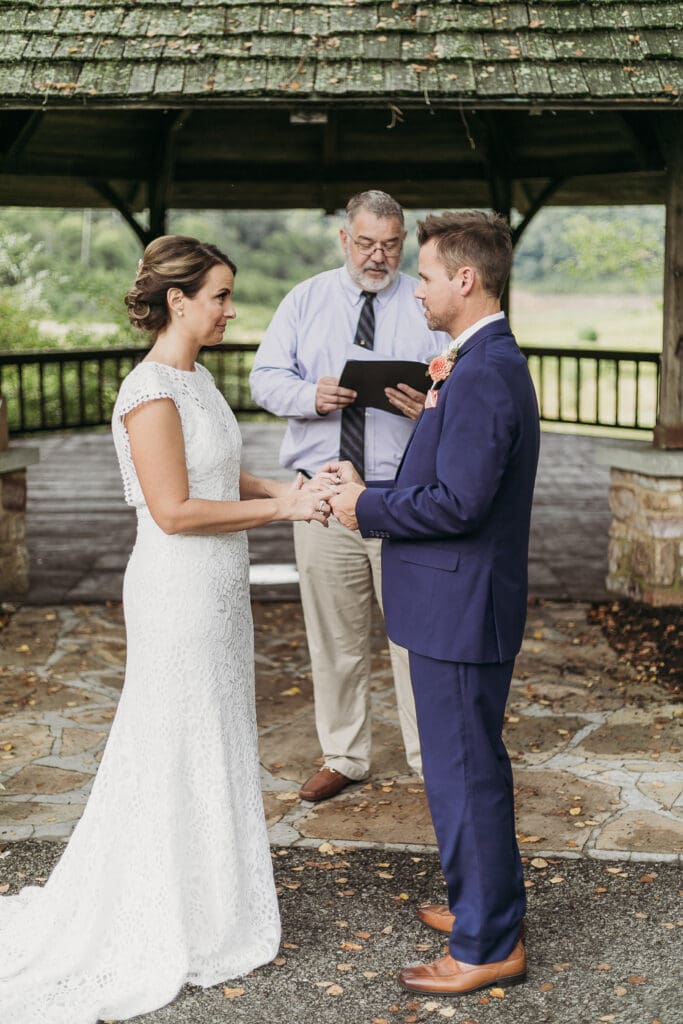 Couple getting married under gazebo eloping in front of the mountains with their son.