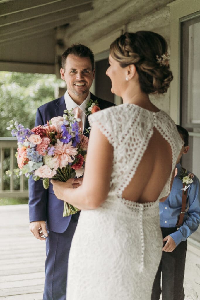 Couple getting married under gazebo eloping in front of the mountains with their son.