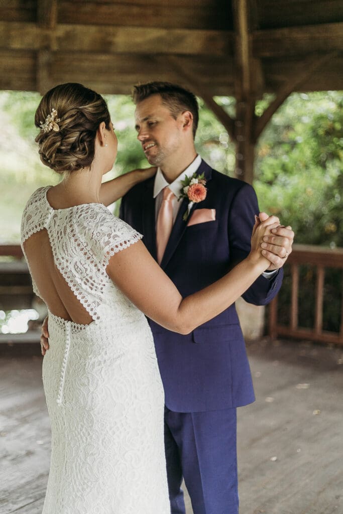 Couple getting married under gazebo eloping in front of the mountains with their son.