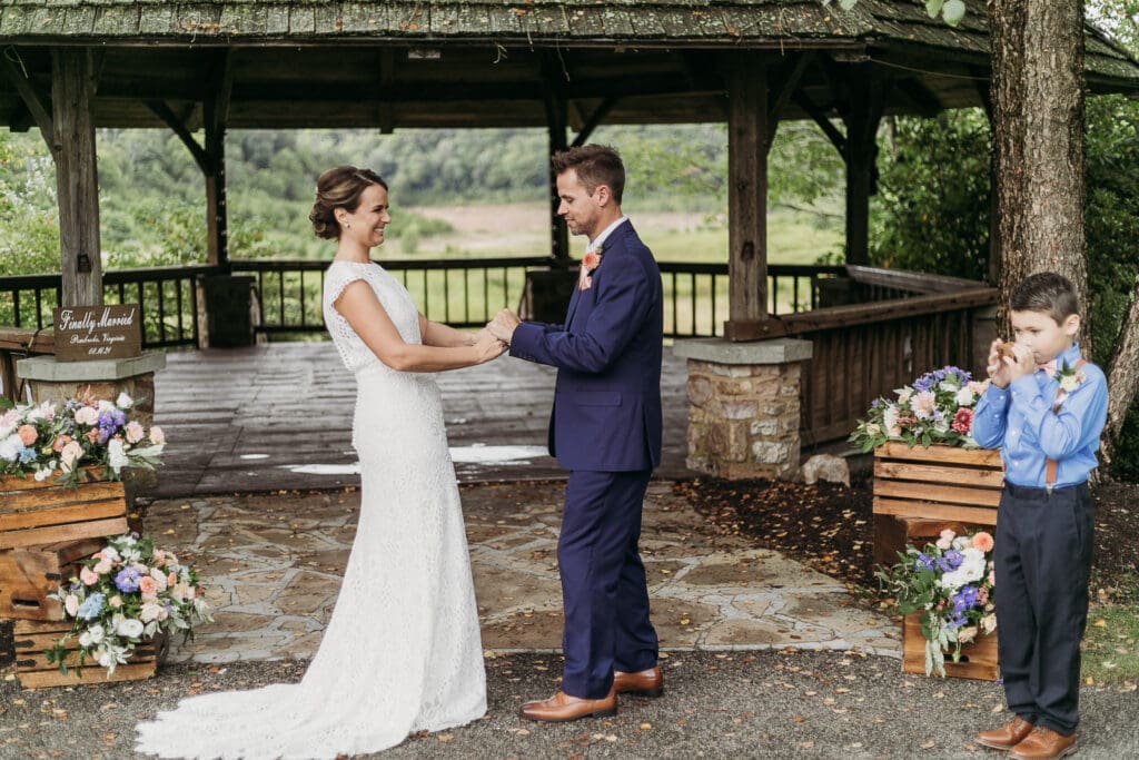 Couple getting married under gazebo eloping in front of the mountains with their son.