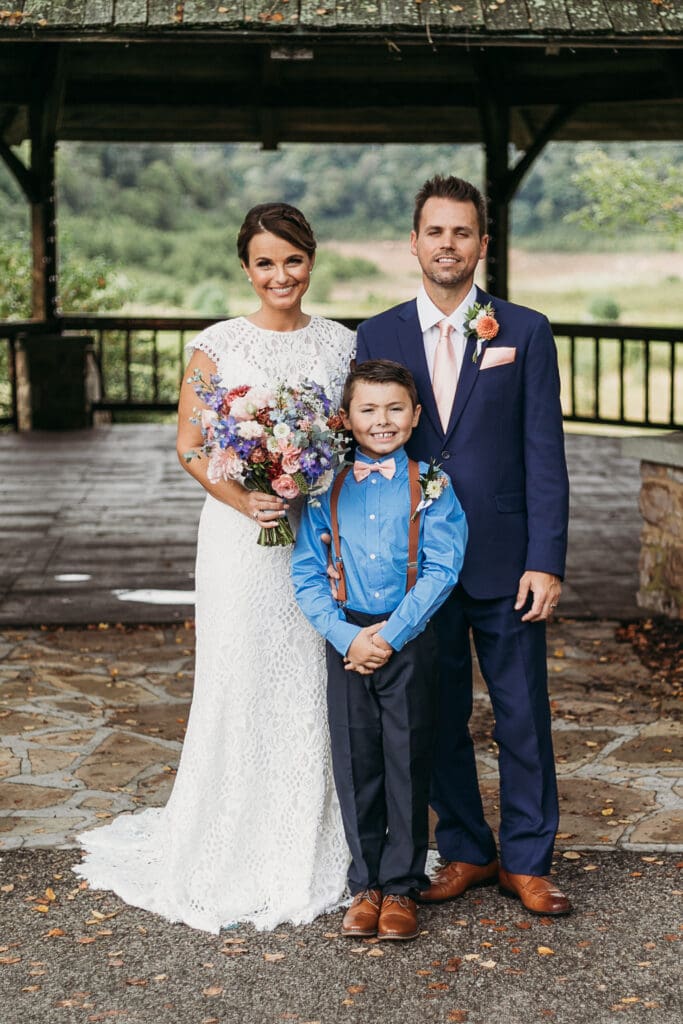 Couple getting married under gazebo eloping in front of the mountains with their son.