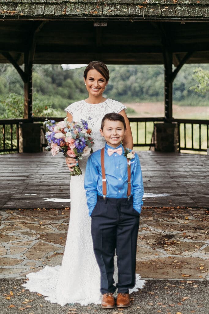 Couple getting married under gazebo eloping in front of the mountains with their son.