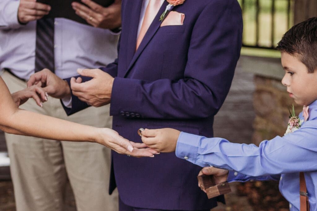 Couple exchanging wedding rings outdoors under gazebo